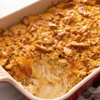 Chicken casserole in a baking dish with a serving scooped out.