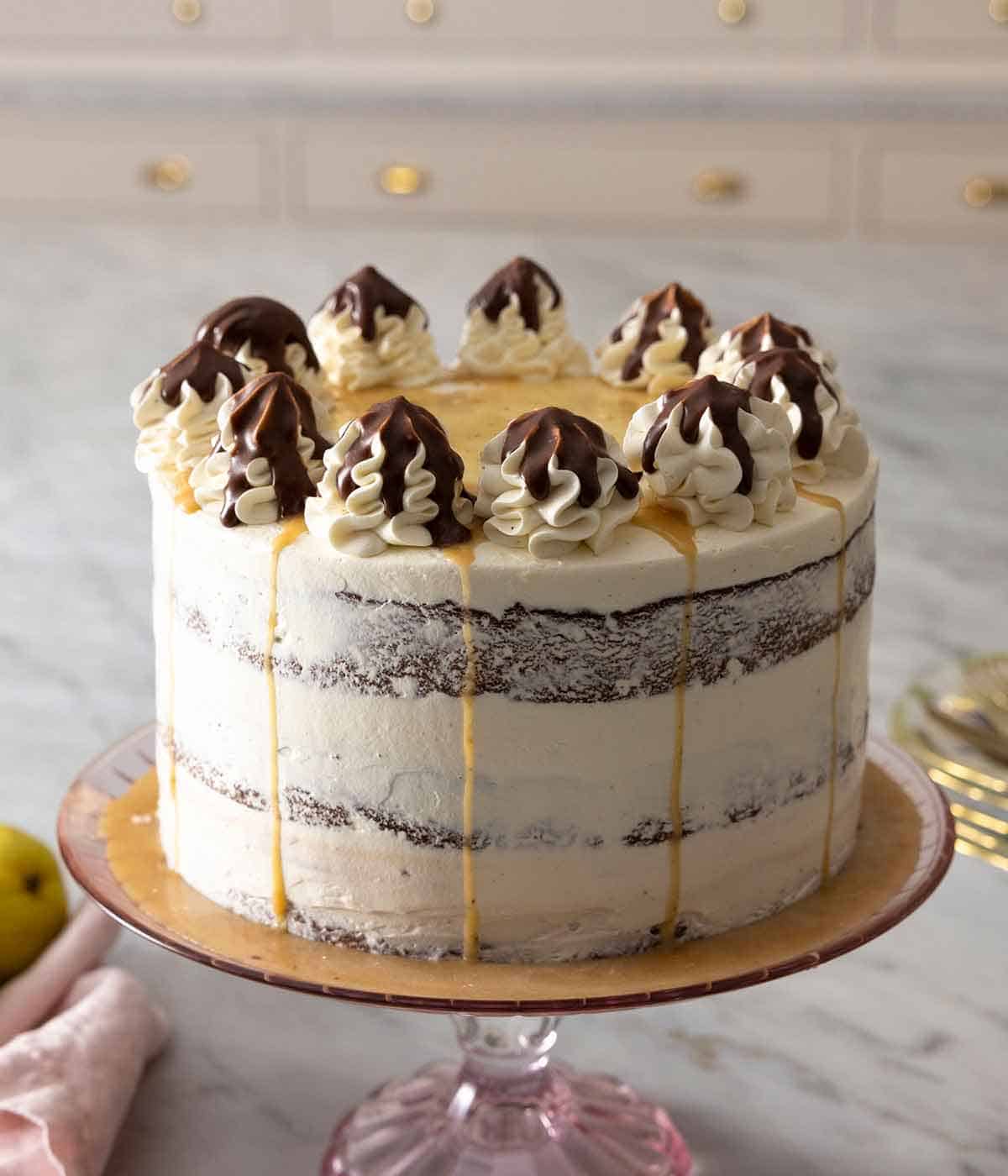 A chocolate pear cake on a cake stand.