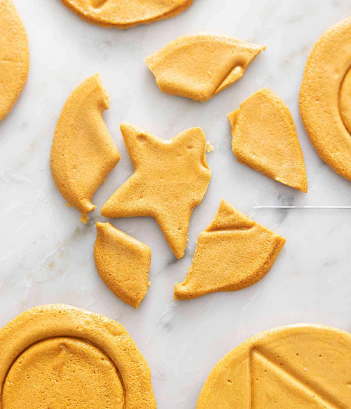 A needle beside a broken dalgona candy.