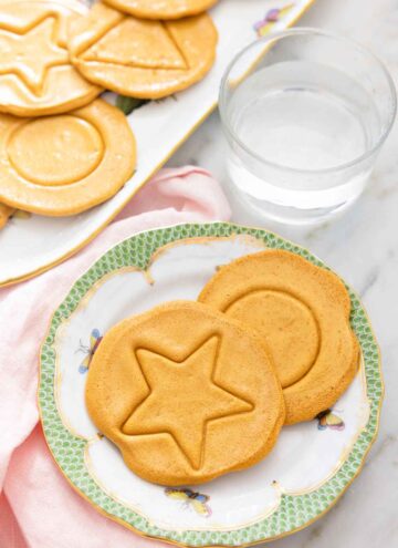 A plate with two dalgona candies with a star and circle shape.