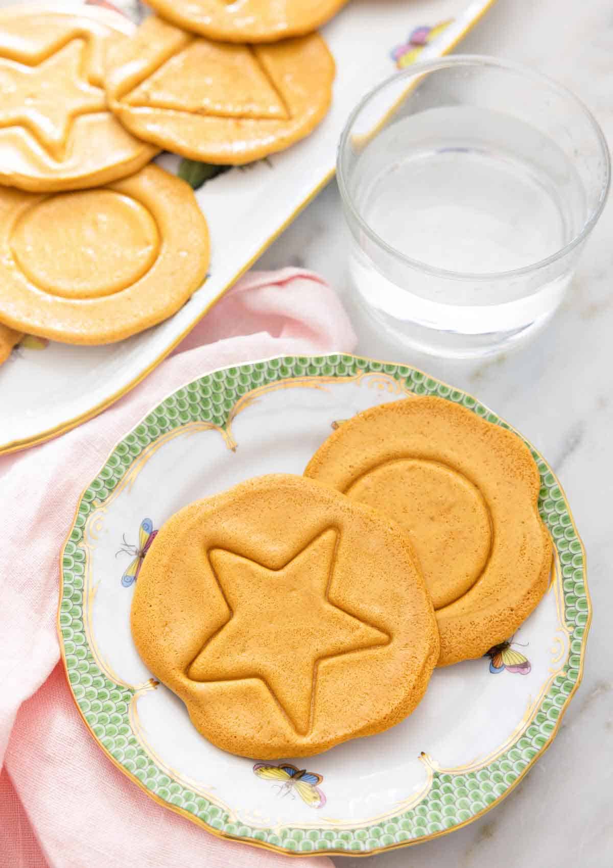A plate with two dalgona candies with a star and circle shape.