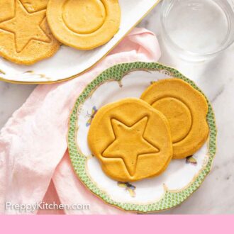 Pinterest graphic of the overhead view of two dalgona candies on a plate beside a platter.