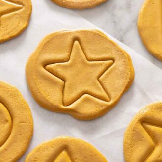Overhead view of dalgona candy with a star in the middle alongside other shapes like triangles and circles.