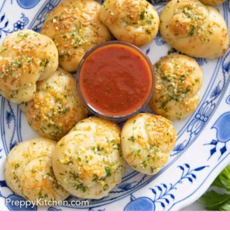 Pinterest graphic of a platter of garlic knots with a bowl of dip.