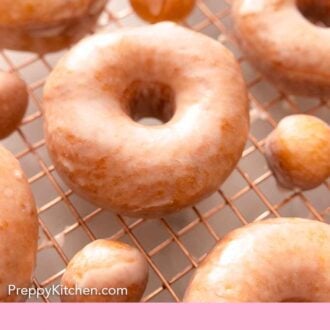 Pinterest graphic of glazed donuts and donut holes on a wire rack.