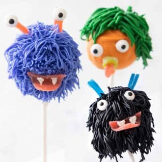 Three monster Halloween cake pops with eyes, mouths, and hair.