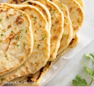 Pinterest graphic of multiple naan breads on a lined plate.