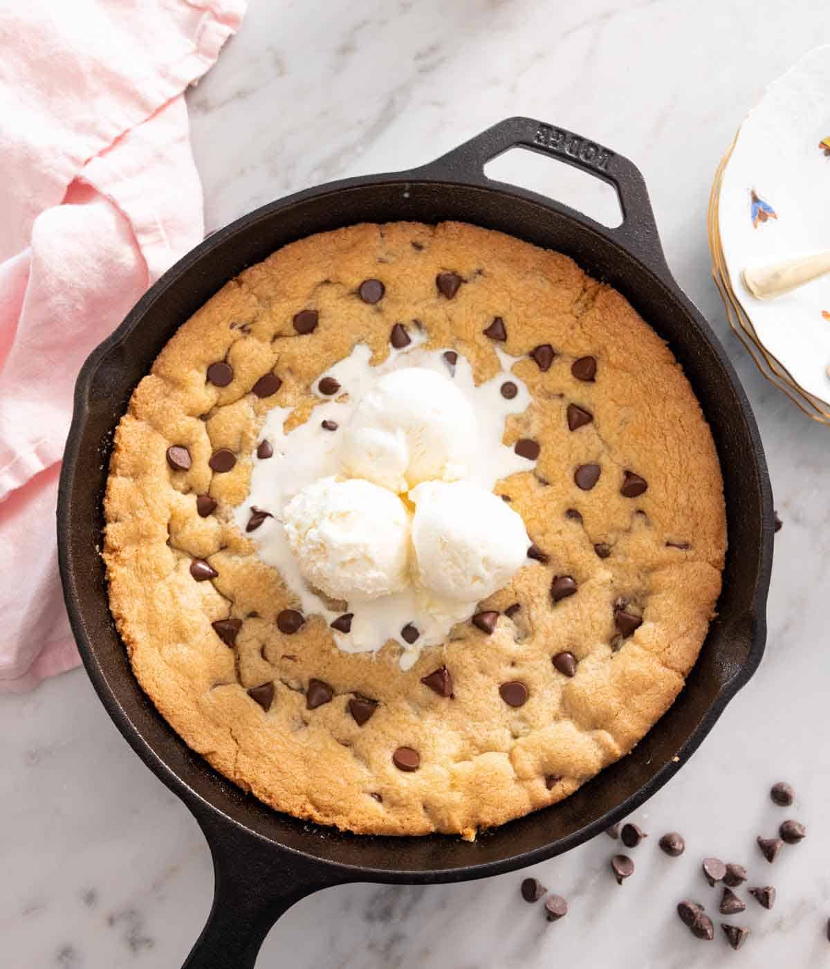 Overhead view of a skillet cookie with ice cream on top.