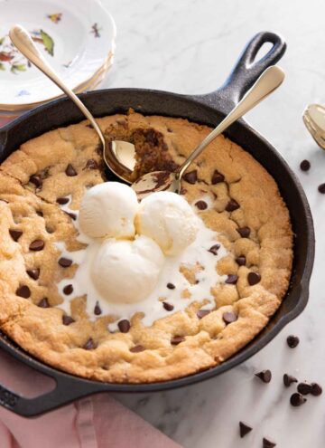 A skillet cookie with three scoops of ice cream on top.