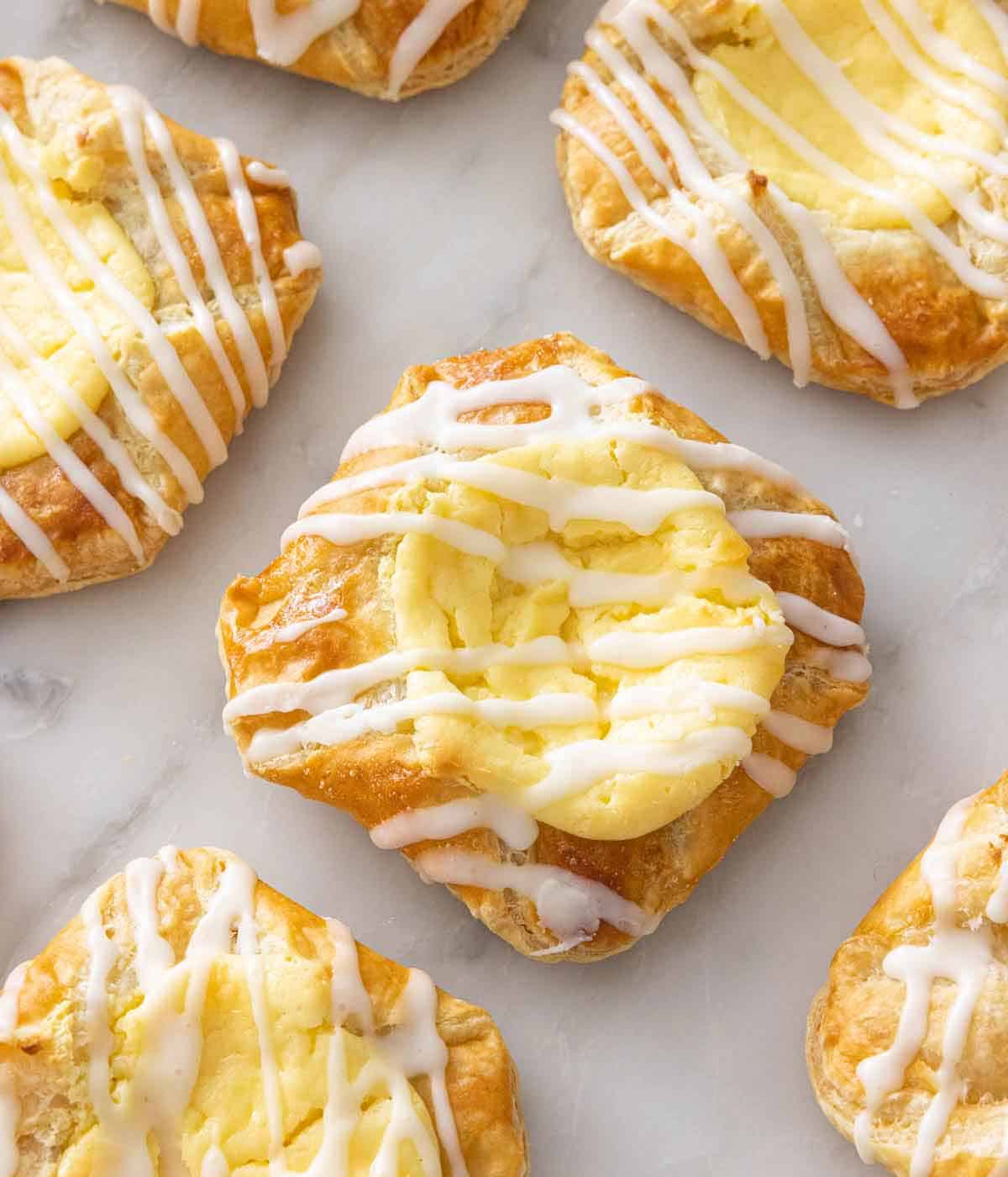 Multiple servings of cheese danish on a marble surface.