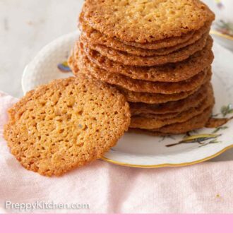 Pinterest graphic of a plate of stacked lace cookies with one on the side.