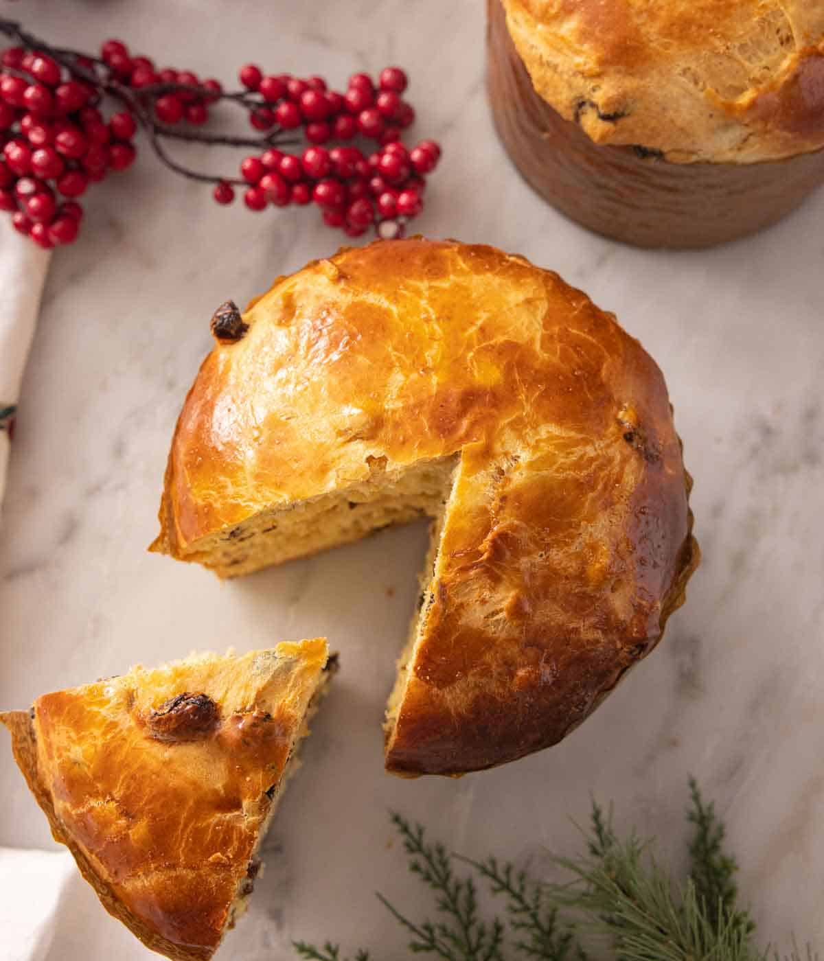 Overhead view of a panettone with a slice cut and pulled forward.