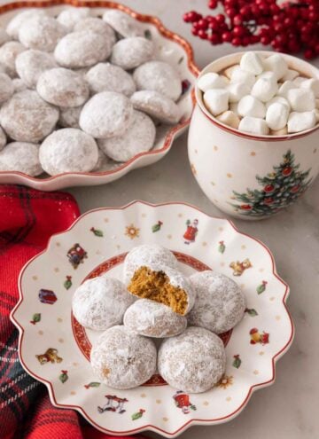 A plate with multiple Pfeffernusse with one bitten in half.