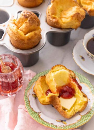 Half of a popovers with butter and jam spread in the middle.