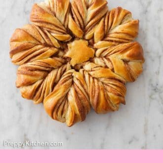 Pinterest graphic of an overhead view of a star bread on a marble surface.
