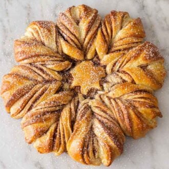 Overhead view of a star bread with a dusting of powdered sugar on top.