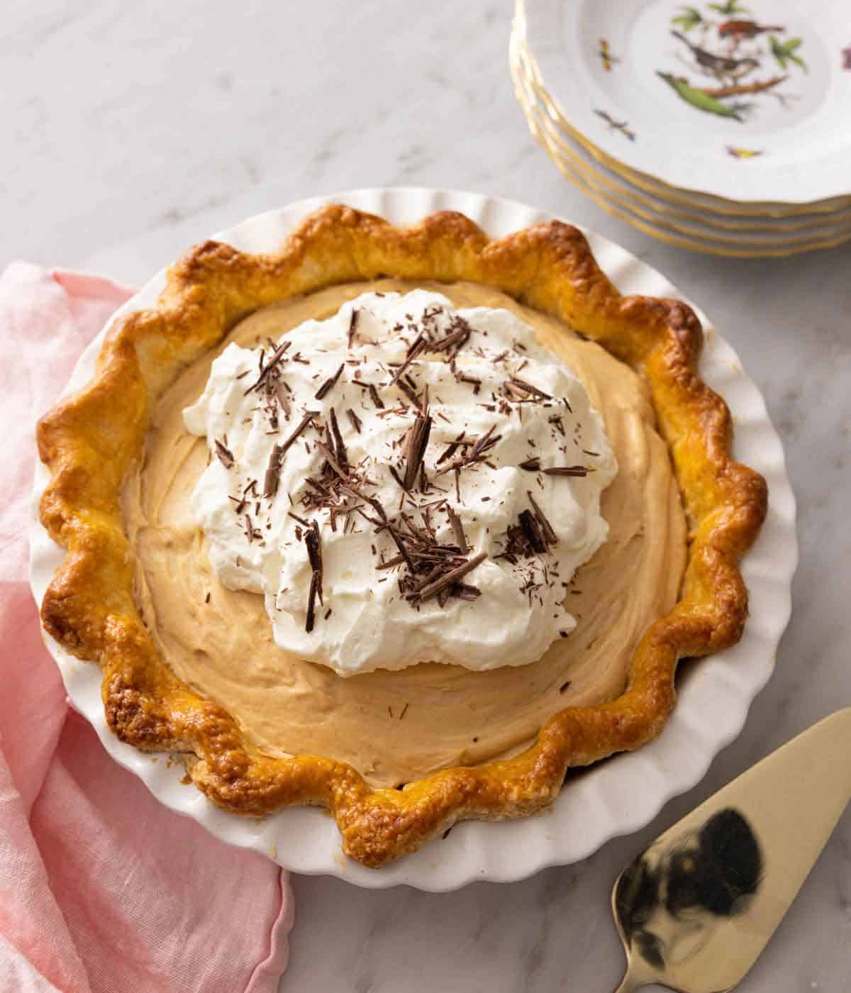 A peanut butter bliss pie with whipped cream on top and chocolate shavings.