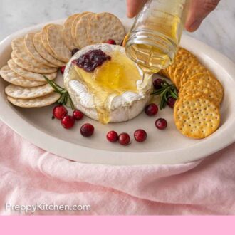 Pinterest graphic of honey being poured over a wheel of baked brie.