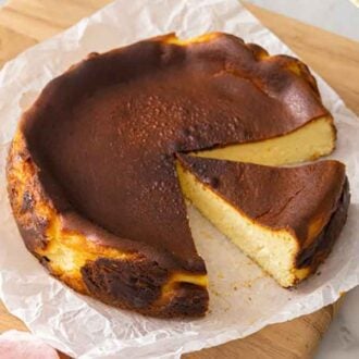 A basque cheesecake with a size cut out and another slice still attached.