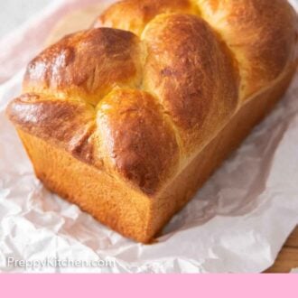 Pinterest graphic of a loaf of brioche bread on a sheet of parchment.
