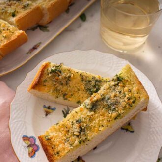 Pinterest graphic of two pieces of garlic bread on a plate.