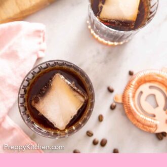 Pinterest graphic of the overhead view of two glasses of Black Russian cocktails with a large cube of ice.