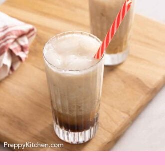 Pinterest graphic of two glasses of Colorado Bulldog cocktails on a wooden serving board.