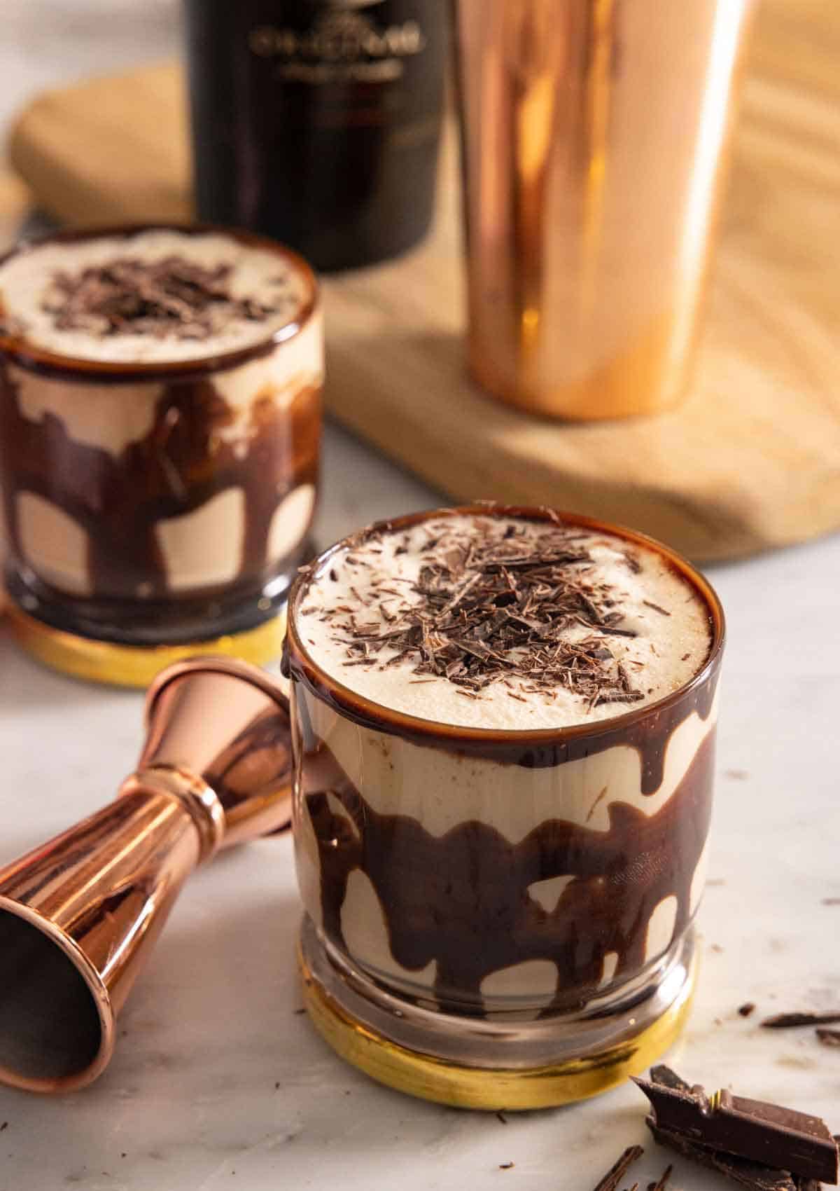 Two glasses of mudslide with shaved chocolate on top.