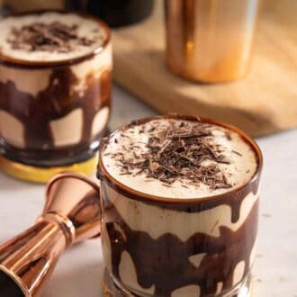 Pinterest graphic of two glasses of mudslides with shaved chocolate on top.