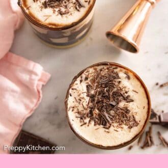 Pinterest graphic of the overhead view of two glasses of mudslide cocktails with a jigger beside them.
