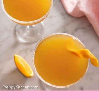 Pinterest graphic of an overhead view of two glasses of sidecar cocktails with orange twist garnish.