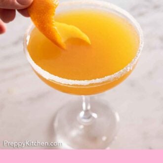 Pinterest graphic of an orange garnish being added to a glass of sidecar cocktail.