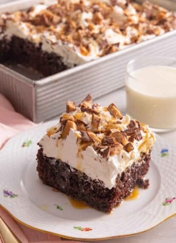 A square piece of better than sex cake by a cup of milk.