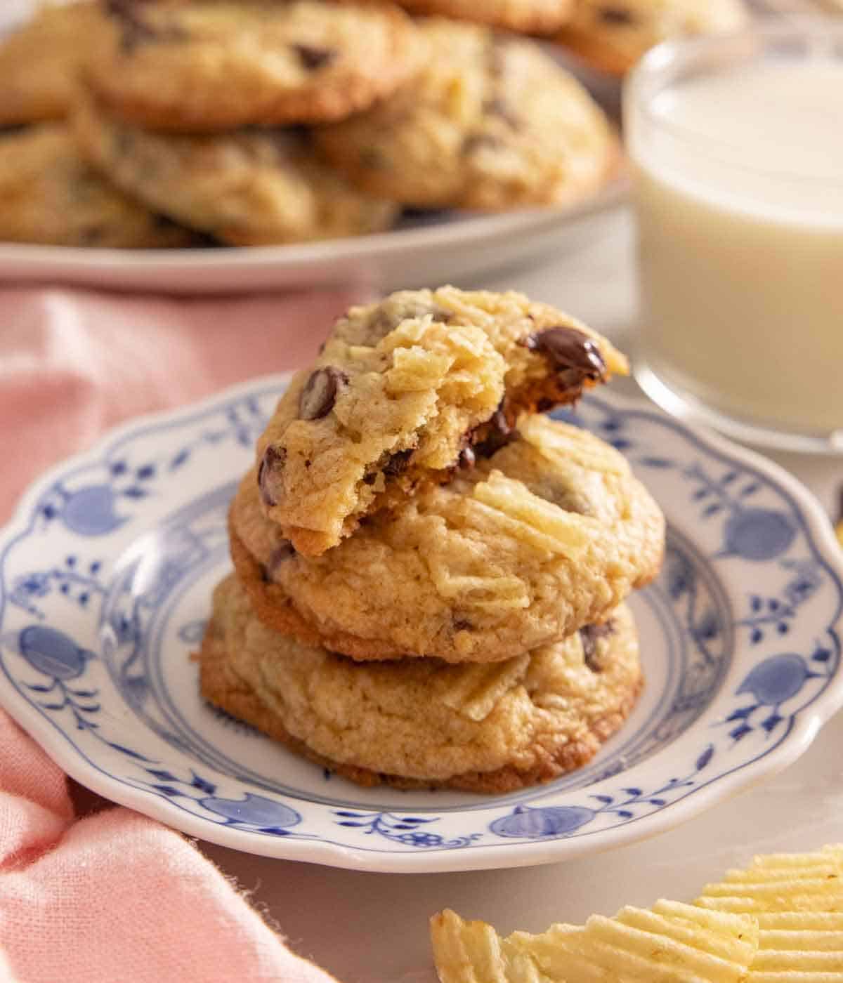 A stack of potato chip cookies with the top one missing half a bite.
