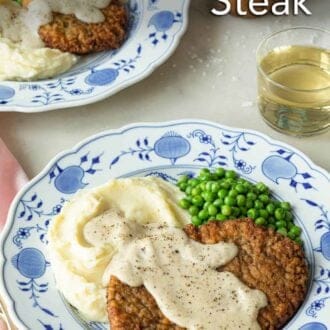 Pinterest graphic of two plates of chicken fried steak with gravy, mashed potatoes, and peas.