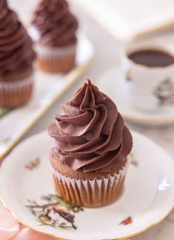 A cupcake with chocolate buttercream frosting piped on top.