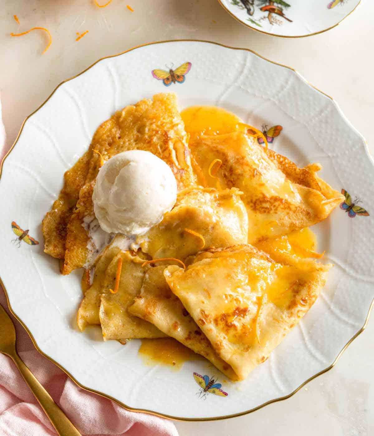 Overhead view of crepe suzette with a scoop of vanilla ice cream.