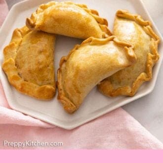 Pinterest graphic of a plate of four empanadas.