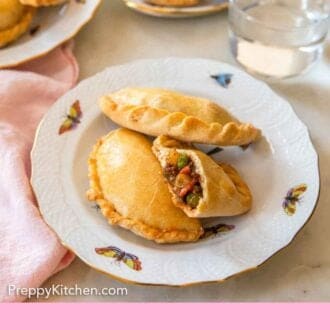 Pinterest graphic of a plate with two and a half empanadas.