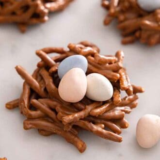A birds nest cookie with candy eggs scattered around it.