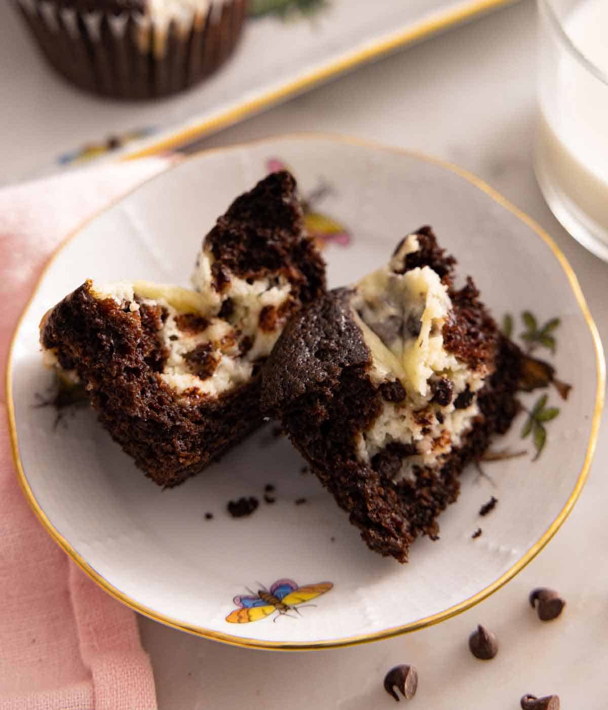 A plate with a black bottom cupcake torn in half.
