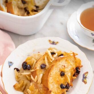 Pinterest graphic of a plate of capirotada by a cup of tea.