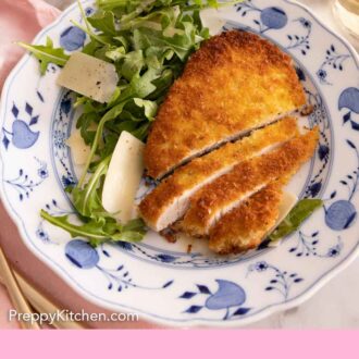 Pinterest graphic of chicken Milanese sliced by a salad.
