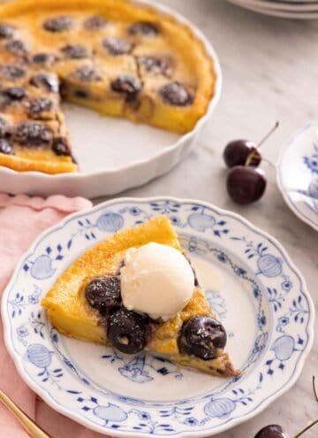 A slice of clafoutis on a plate with a scoop of ice cream on top.