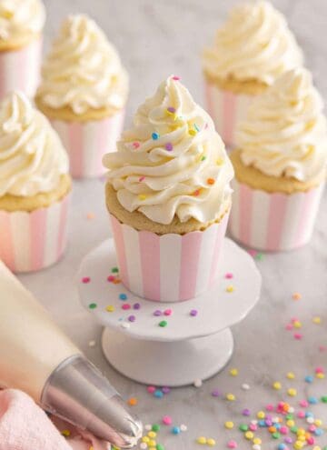 Multiple cupcakes with Italian buttercream piped on top with sprinkles.