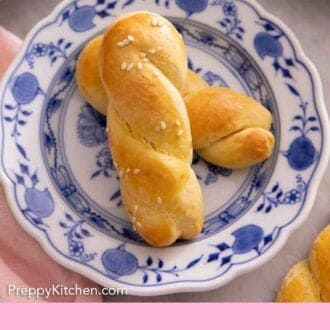 Pinterest graphic of a blue and white plate with two koulourakia.