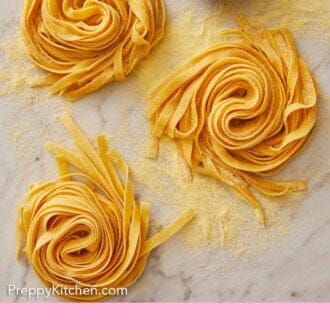Pinterest graphic of an overhead view of three bundles of pasta dough with semolina flour dusted on top.