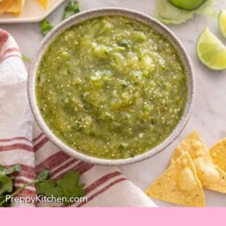 Pinterest graphic of an overhead view of a bowl of salsa verde with ingredients surrounding it.