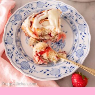 Pinterest graphic of a strawberry roll on a plate with a bite missing and a forkful of the roll beside it.