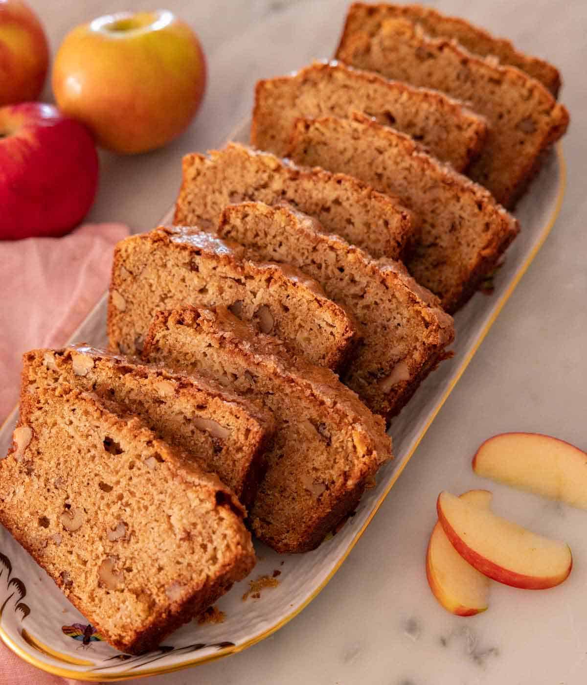 A long platter of an apple bread cut into ten slices.